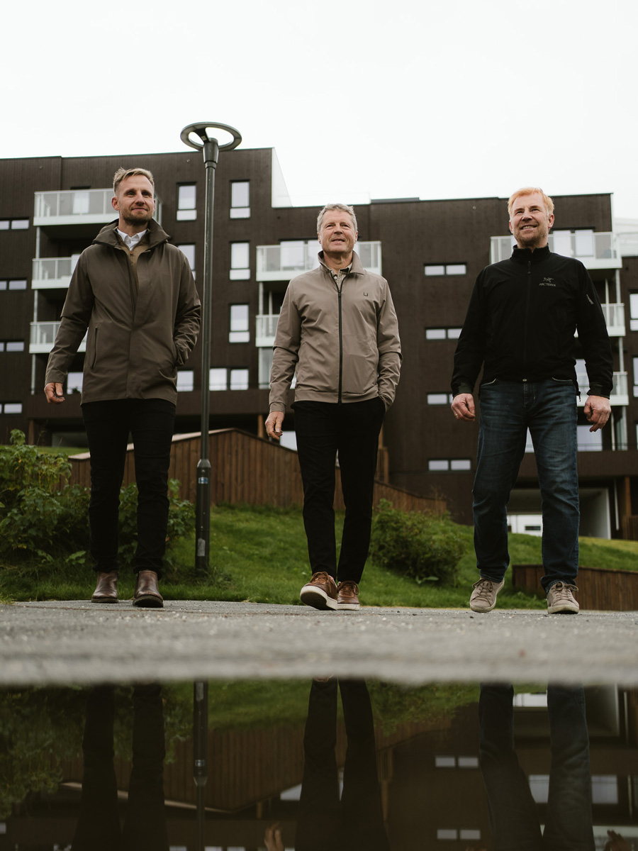 De tre i Frabene foran et av selskapets boligbygg i Tromsø.